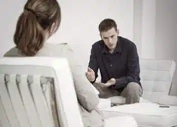hombre sentado hablando con su psicóloga hombre sentado hablando con su psicóloga